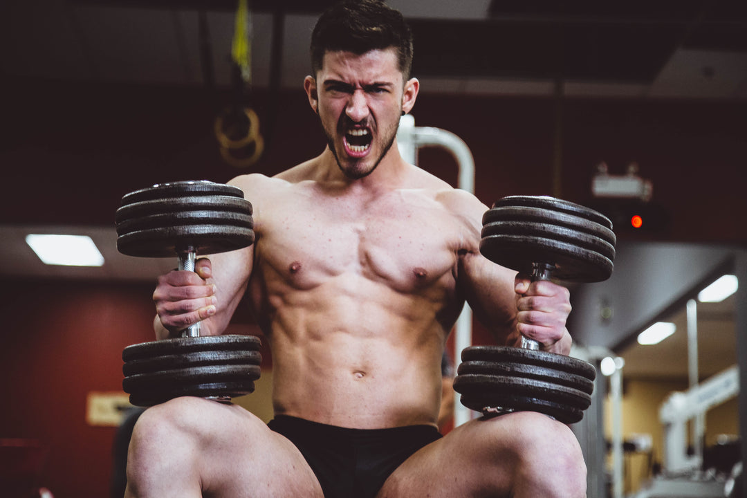 Athlete with heavy dumbbells highlights his toned muscles, a benefit of collagen according to sports research on collagen peptides