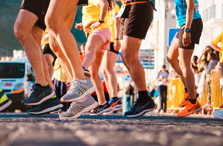 Knee level shot of runners who have replenished their bodies with liquid protein shots for maximum performance