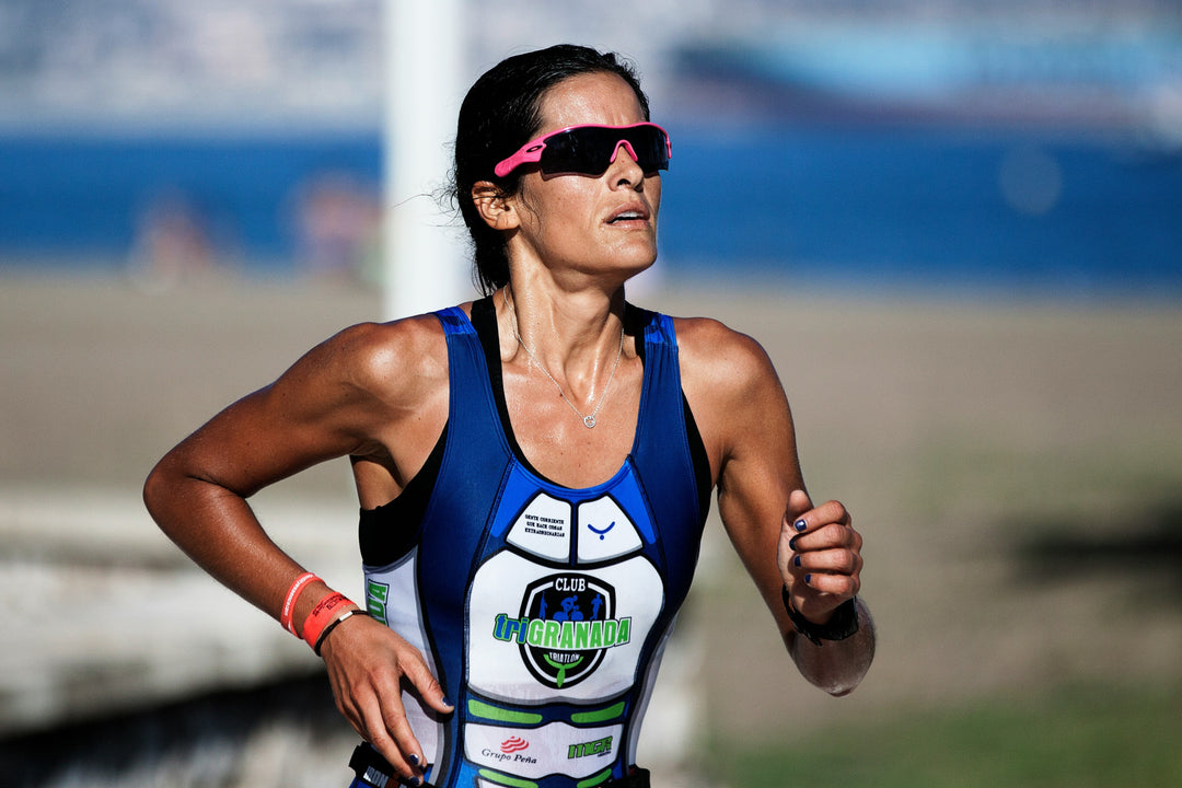 Female triathlete fully aware of how to avoid knee pain while running is competing in a triathlon
