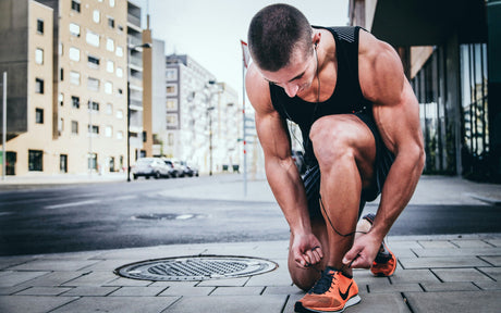 Professional athlete, taking a moment to rest his muscles to promote post-workout recovery after sprinting