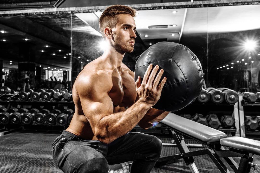 Male athlete doing medicine ball squat for ACL injury prevention
