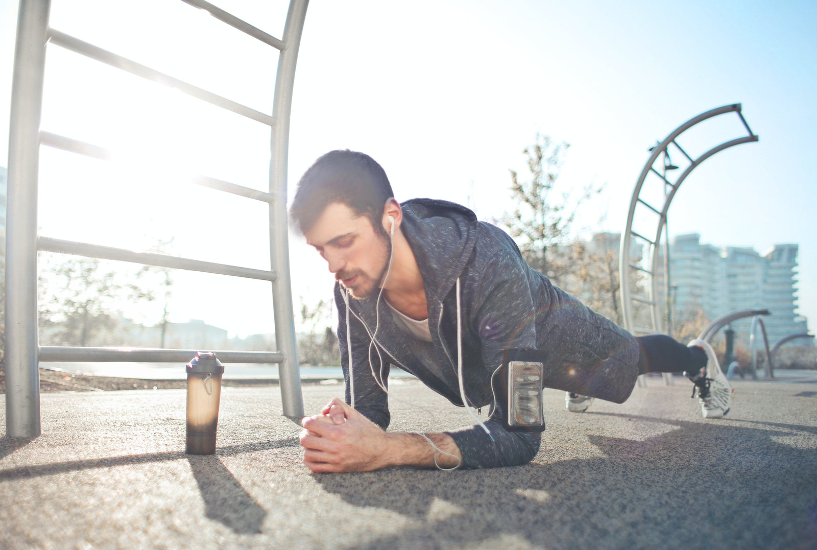 Young man doing push ups at a park while listening to a podcast about liquid collagen benefits