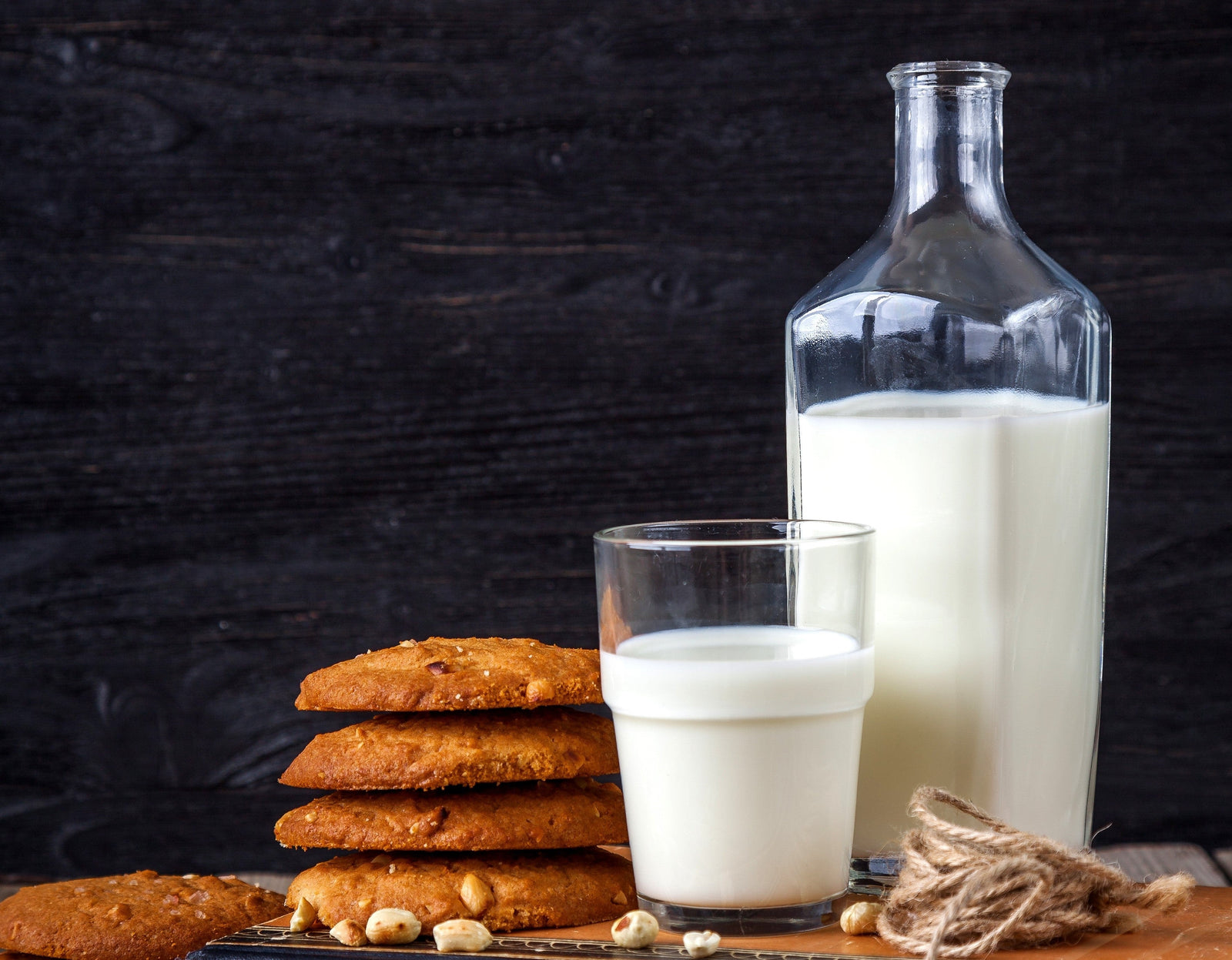 A bottle and a cup of liquid protein next to a stack of cookies