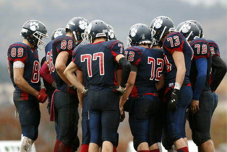 A team of young football players are gathered around to discuss their high school football nutrition plan