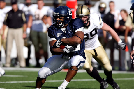 Football game in progress, with two players engaged in a play as a result of football conditioning