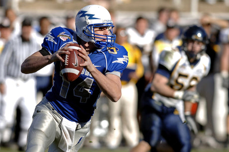 Quarterback fueled by the best protein powder for young athletes runs with the ball in a football stadium