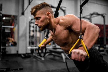 Athlete deliberating, "Can I drink two protein shakes in a day?" while in the midst of a grueling workout routine at a well-equipped gym