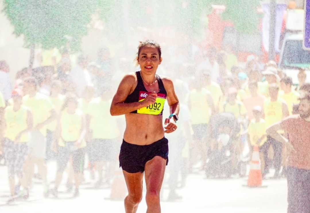 Female athlete energized by goo energy supplement is remarkably swift as she runs during a tough marathon race