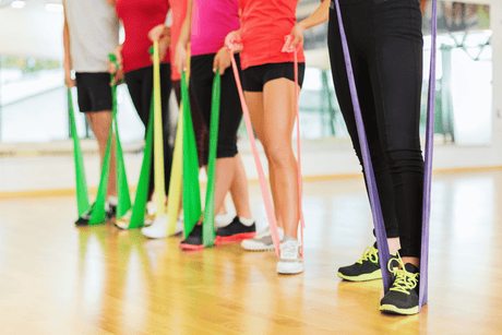 Group of athletes stretching with resistance bands - one method on how to heal shin splints fast