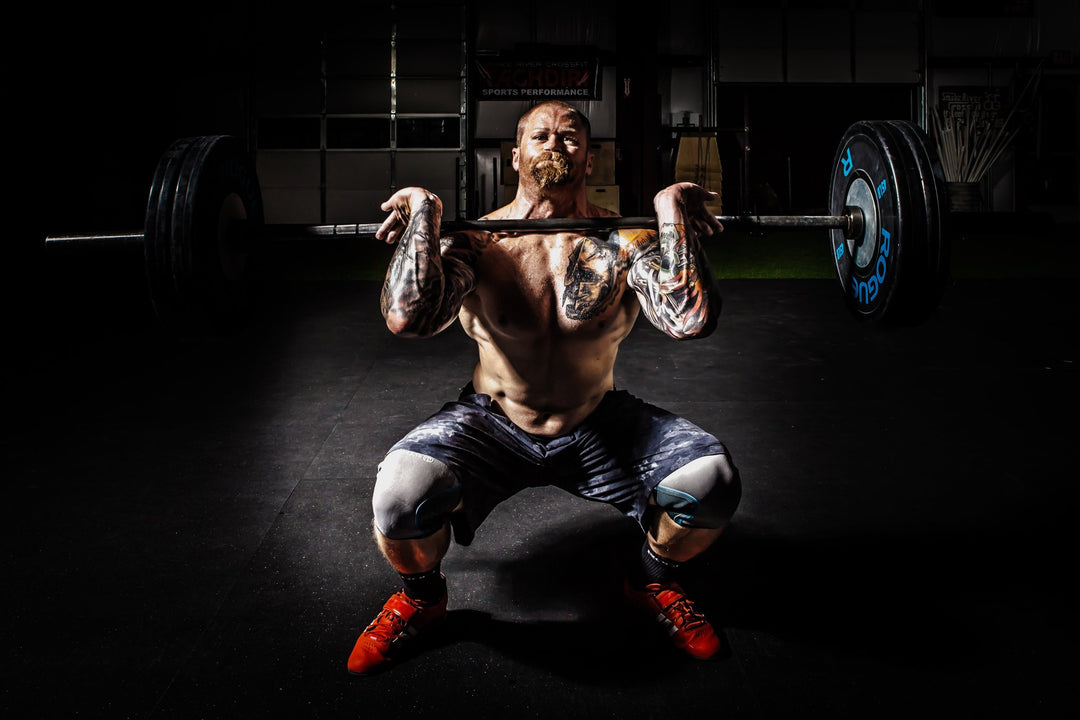 Strong athlete powered by top collagen supplements and dedicated training is performing a squat while lifting a heavy barbell